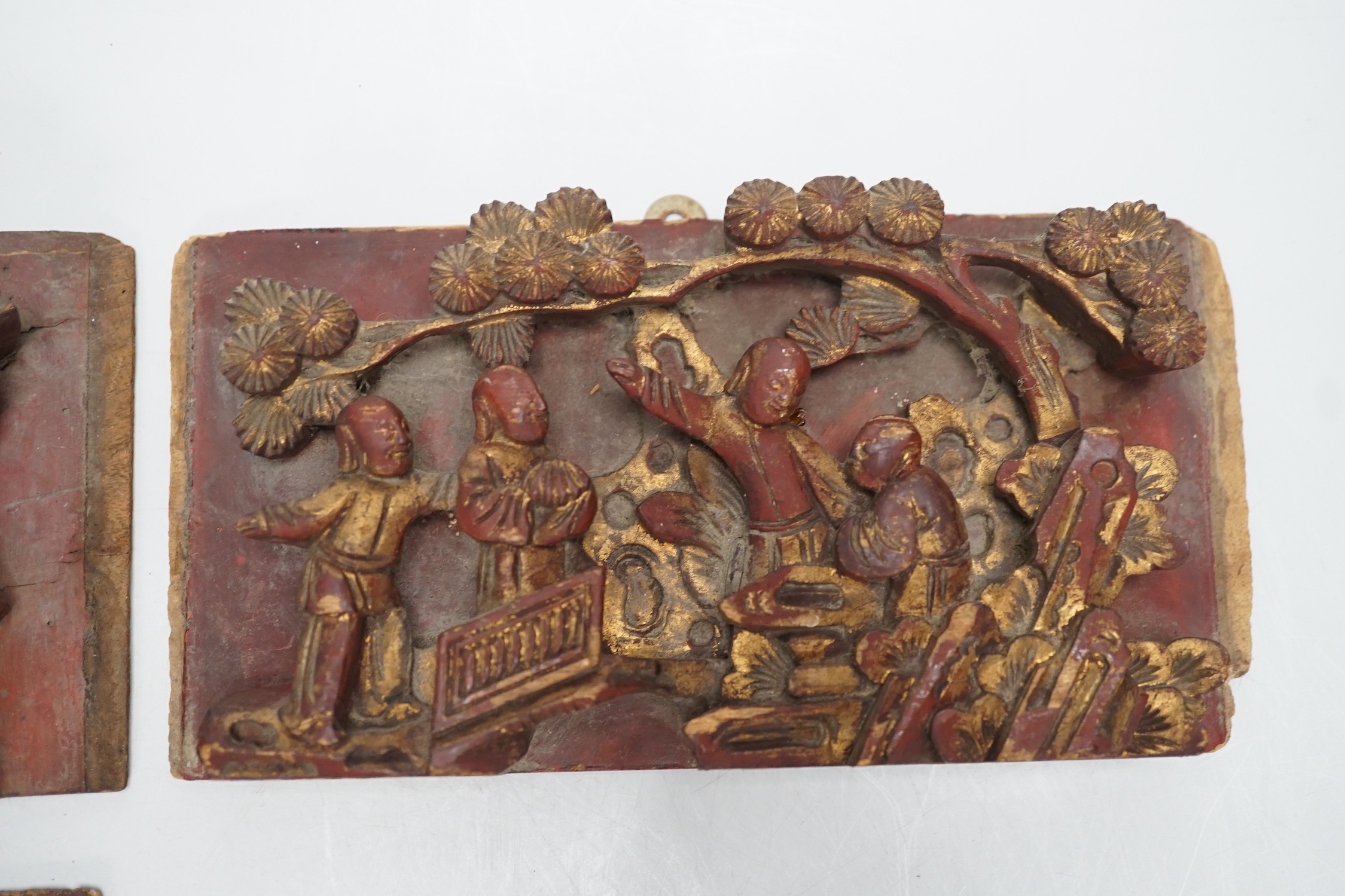 Three Chinese gilded and lacquered wood figural panels and two similar dragon and phoenix crest pieces (5), late 19th century
